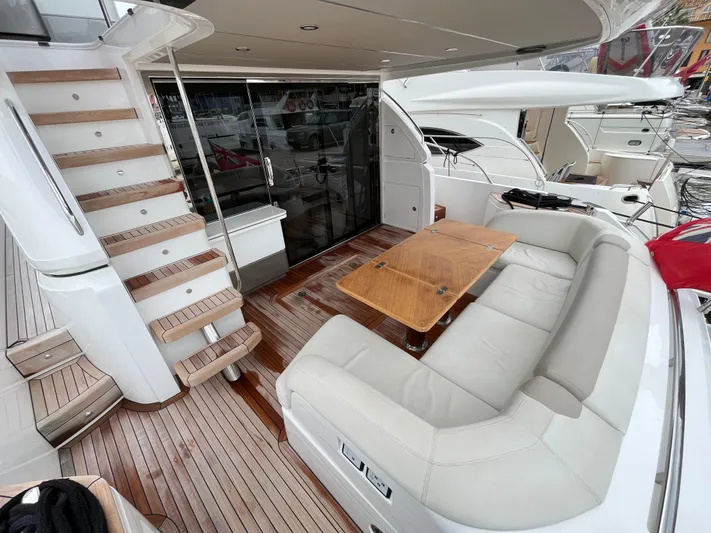 Amussay Yacht Photos Pics Luxurious 2020 Princess F62 yacht deck with seating and wooden table.