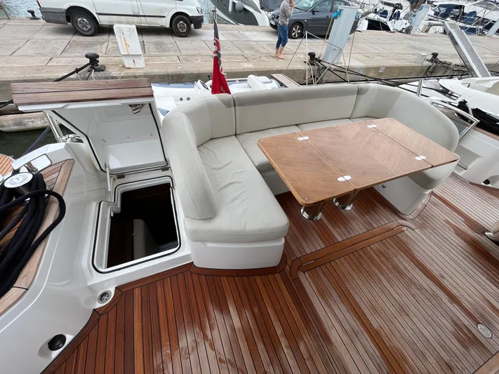 Amussay Yacht Photos Pics Luxurious 2020 Princess F62 yacht deck with seating and wooden table.