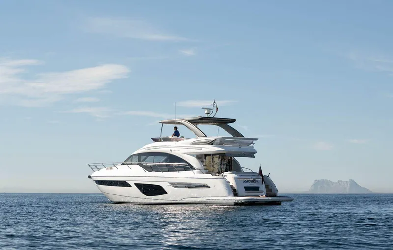Amussay Yacht Photos Pics Luxurious 2020 Princess F62 yacht cruising on calm ocean waters under a clear blue sky.