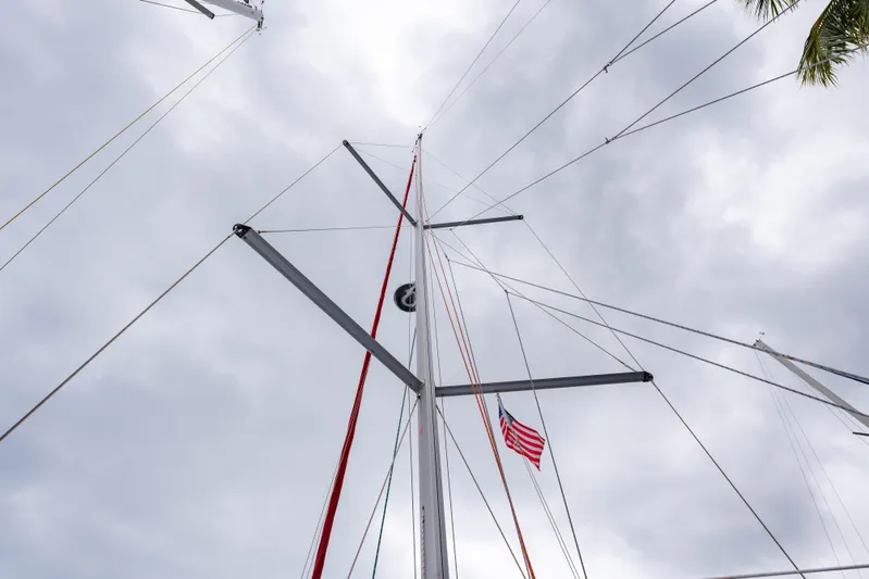 Siman H Yacht Photos Pics Mast of 2020 Beneteau Oceanis 46.1 sailboat with American flag against cloudy sky.