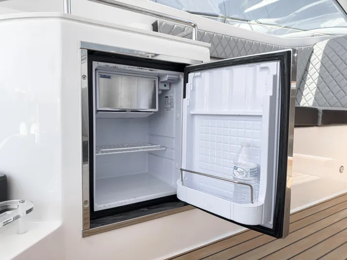 Adamas Yacht Photos Pics Open mini fridge on Schaefer 400 yacht, 2021 model, with a water bottle inside.
