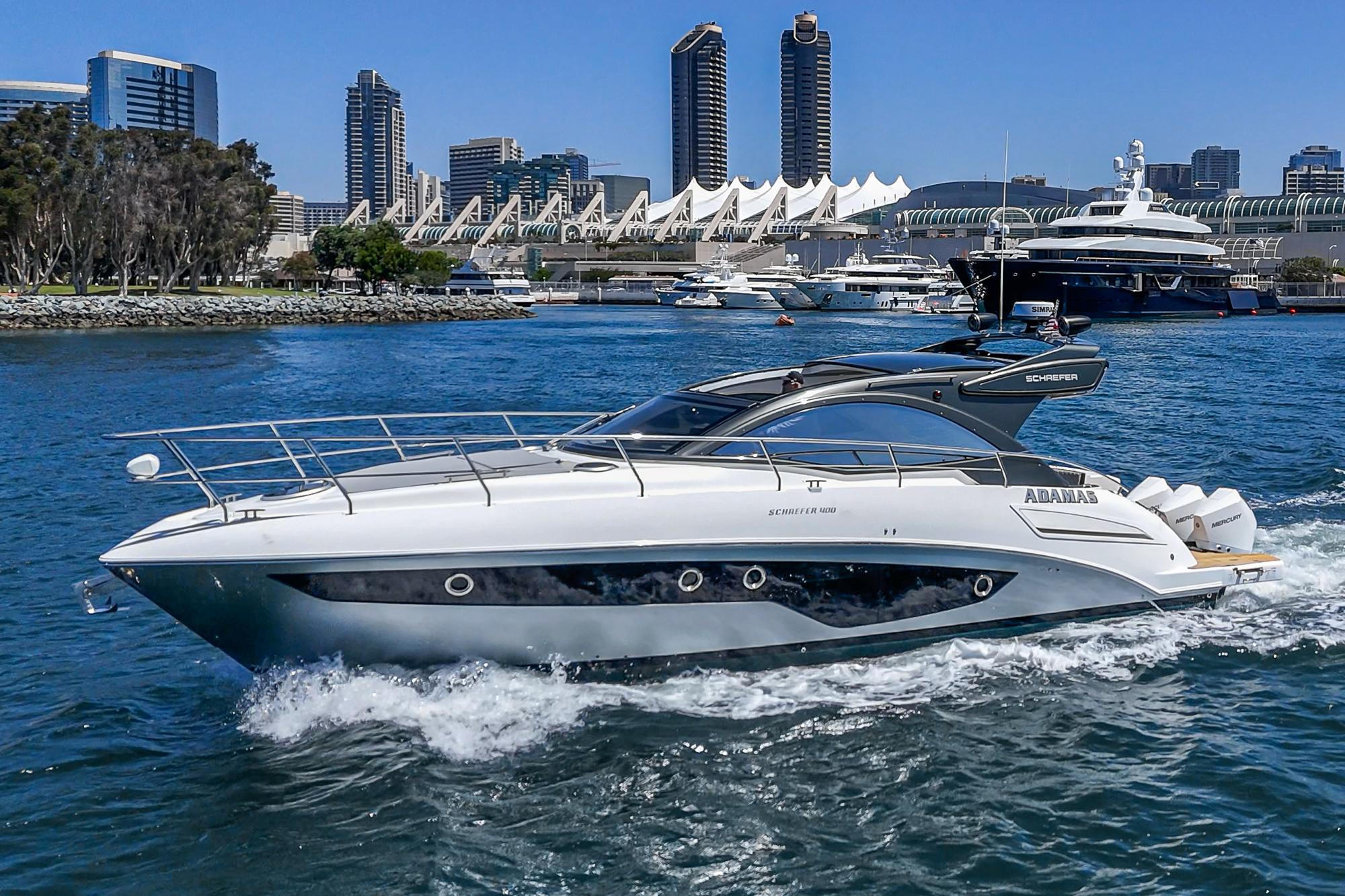 2021 Schaefer 400 yacht cruising in urban waterfront with city skyline.