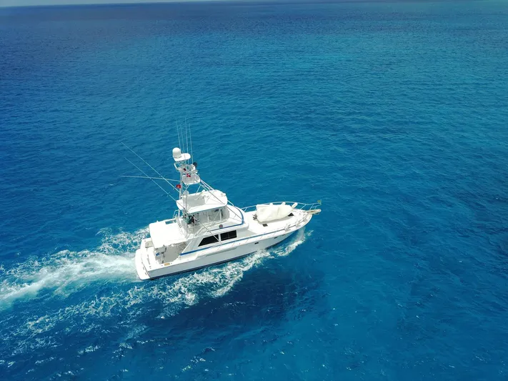 Maple Leaf Yacht Photos Pics 1981 Bertram Convertible yacht cruising on clear blue ocean waters.