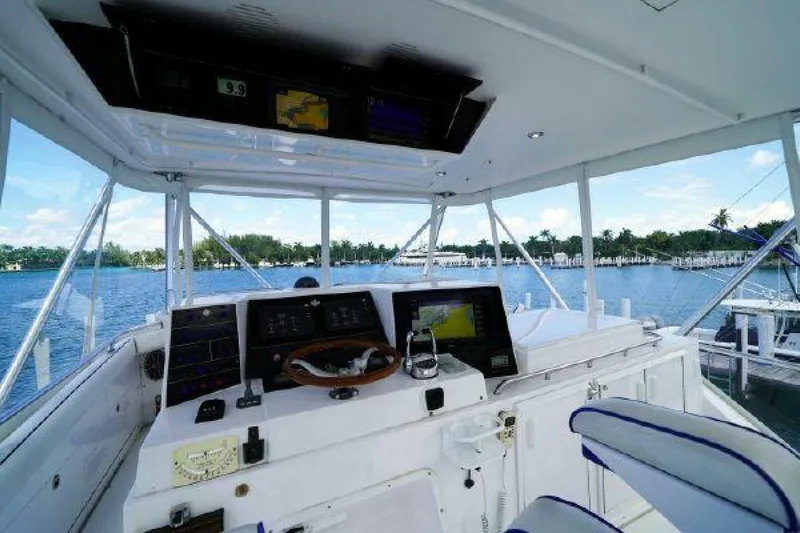 Maple Leaf Yacht Photos Pics 1981 Bertram Convertible boat cockpit with navigation equipment and waterfront view.