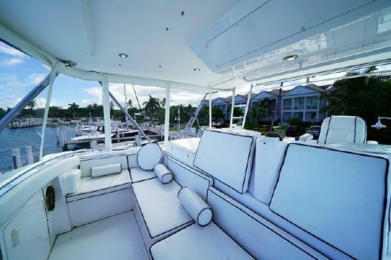 Maple Leaf Yacht Photos Pics 1981 Bertram Convertible yacht interior with white cushioned seating and marina view.