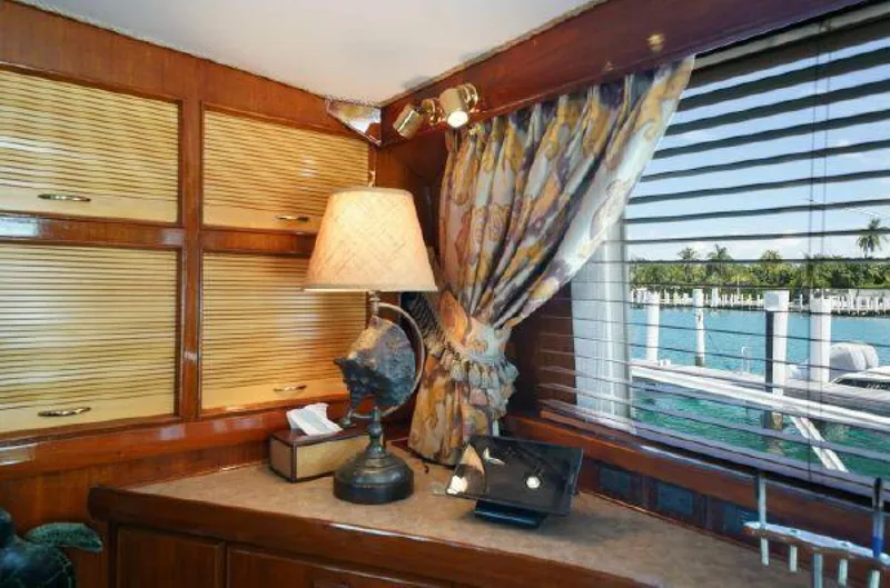 Maple Leaf Yacht Photos Pics 1981 Bertram Convertible yacht interior with wooden cabinets, lamp, and ocean view.
