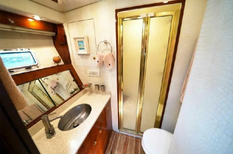 Maple Leaf Yacht Photos Pics 1981 Bertram Convertible yacht bathroom with sink, mirror, and shower.