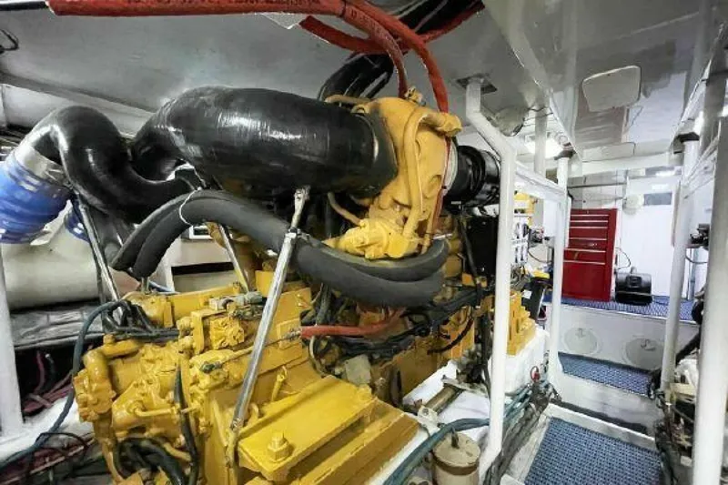 Maple Leaf Yacht Photos Pics Engine room of a 1981 Bertram Convertible boat with visible machinery.