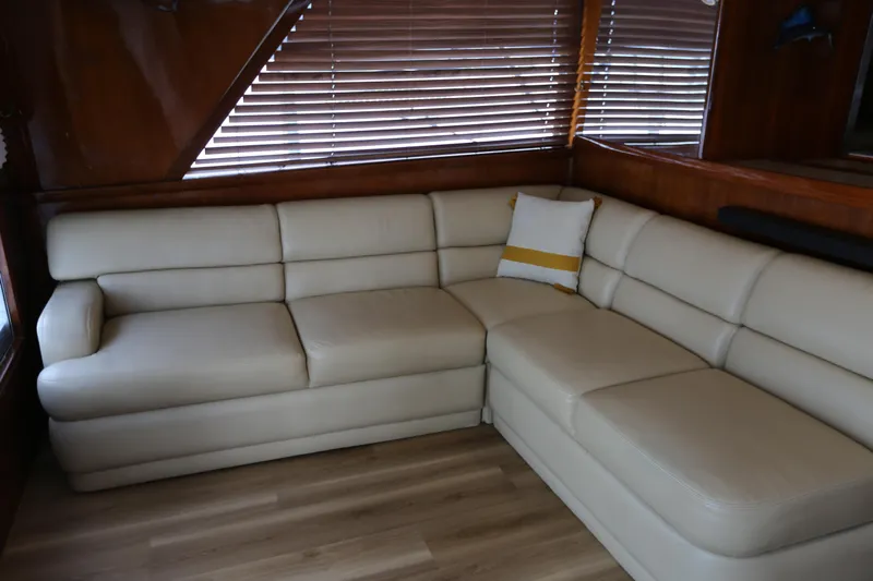 Maple Leaf Yacht Photos Pics Cream leather sofa in 1981 Bertram Convertible yacht interior, with wooden blinds and flooring.