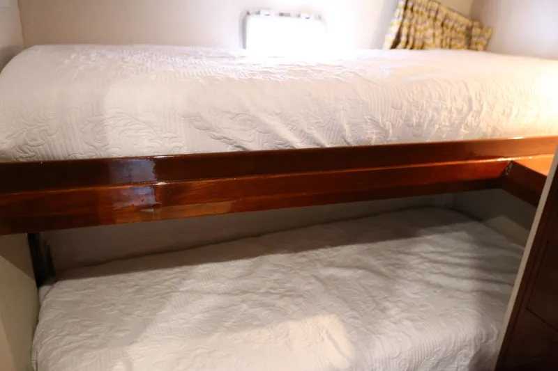 Maple Leaf Yacht Photos Pics Bunk beds in a 1981 Bertram Convertible yacht cabin with white bedding.