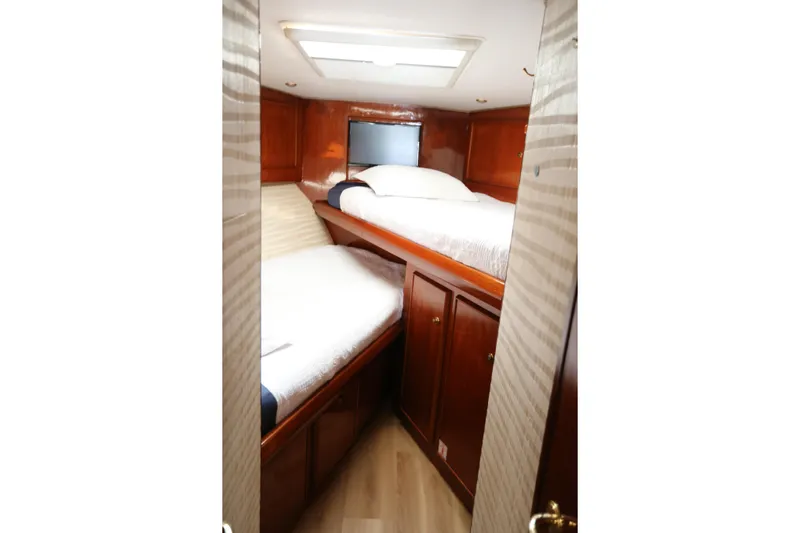 Maple Leaf Yacht Photos Pics 1981 Bertram Convertible cabin interior with wooden finish and twin beds.
