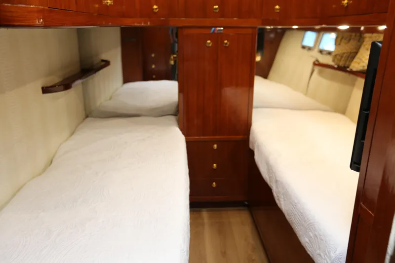 Maple Leaf Yacht Photos Pics Interior of 1981 Bertram Convertible yacht with twin beds and wooden cabinetry.