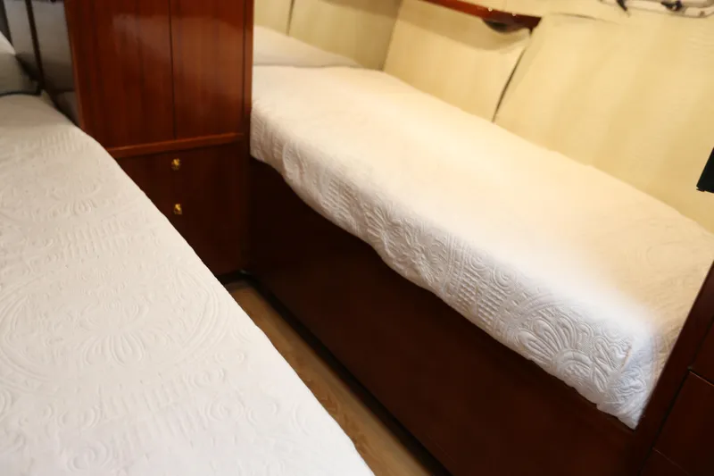 Maple Leaf Yacht Photos Pics 1981 Bertram Convertible interior with twin beds and wooden cabinetry.