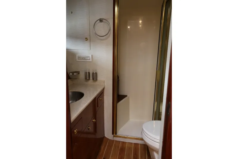 Maple Leaf Yacht Photos Pics Bathroom interior of 1981 Bertram Convertible yacht with shower and sink.