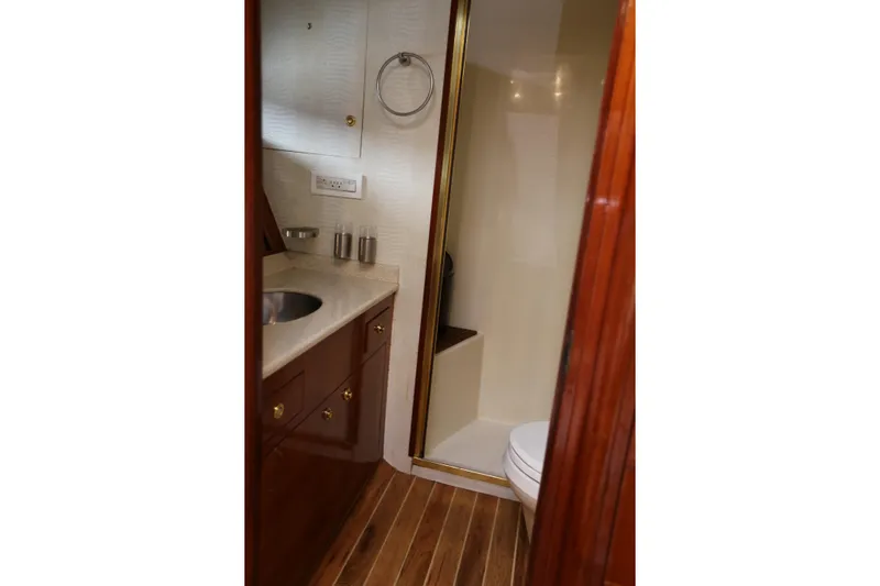 Maple Leaf Yacht Photos Pics 1981 Bertram Convertible yacht bathroom with wood accents and modern fixtures.