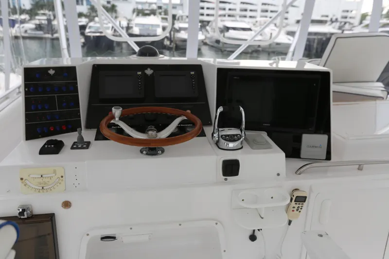 Maple Leaf Yacht Photos Pics 1981 Bertram Convertible helm with steering wheel, navigation screens, and control panel.