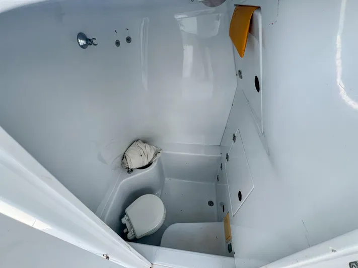  Yacht Photos Pics Compact bathroom in a 2001 Venture 34 boat, featuring a toilet and storage compartments.