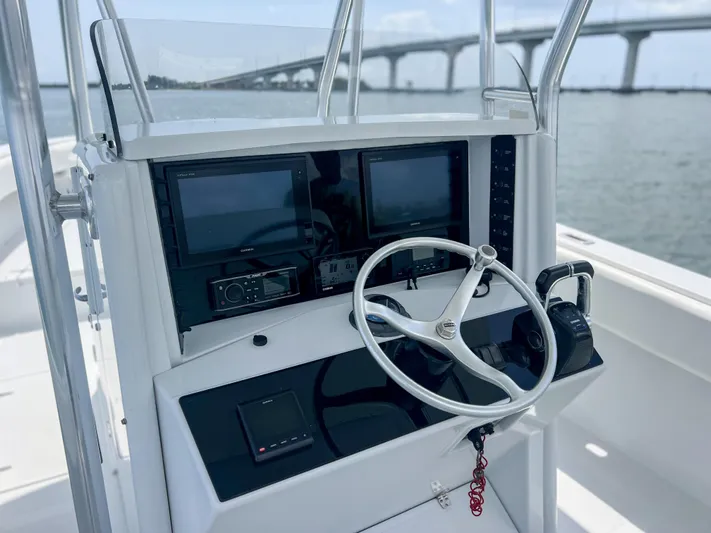  Yacht Photos Pics Helm of 2001 Venture 34 boat with steering wheel and navigation screens, bridge in background.