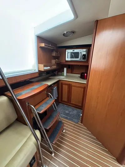 Aubreezy Yacht Photos Pics 2007 Luhrs 41 Express yacht interior with wooden cabinetry and compact kitchen area.