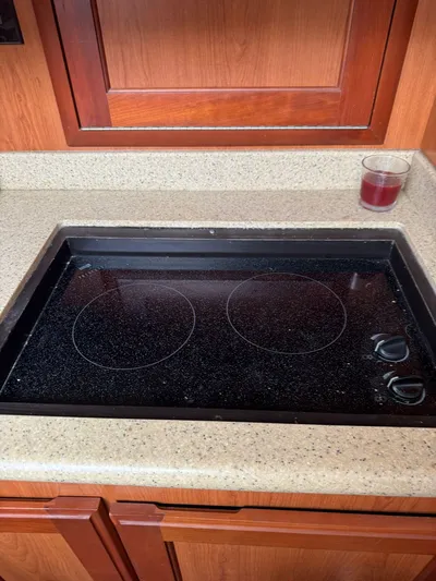 Aubreezy Yacht Photos Pics 2007 Luhrs 41 Express kitchen with electric stovetop and wooden cabinetry.