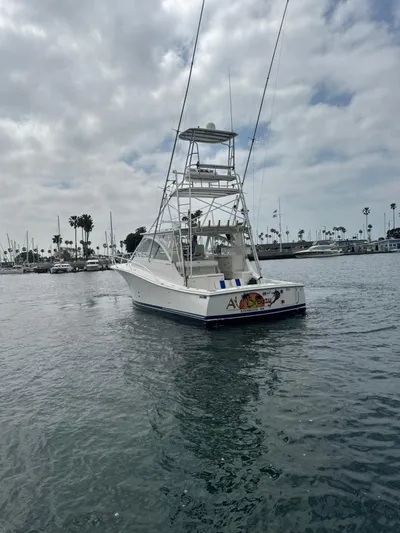 Aubreezy Yacht Photos Pics 2007 Luhrs 41 Express boat on calm water, cloudy sky, marina background.