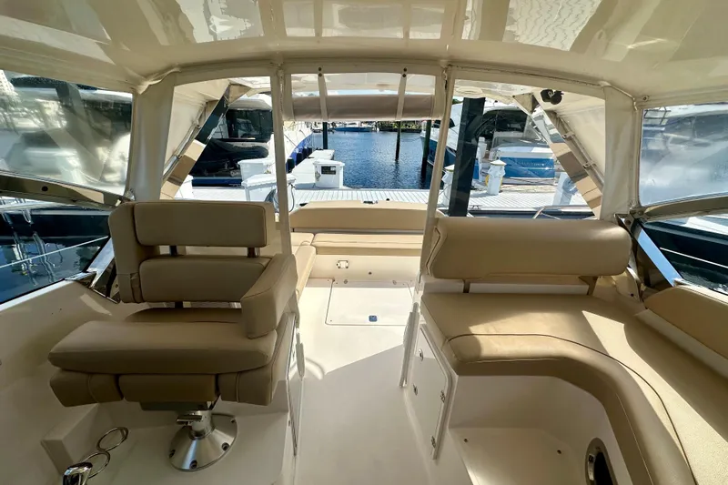  Yacht Photos Pics Interior of 2015 Pursuit SC 365i Sport Coupe with beige seating and marina view.