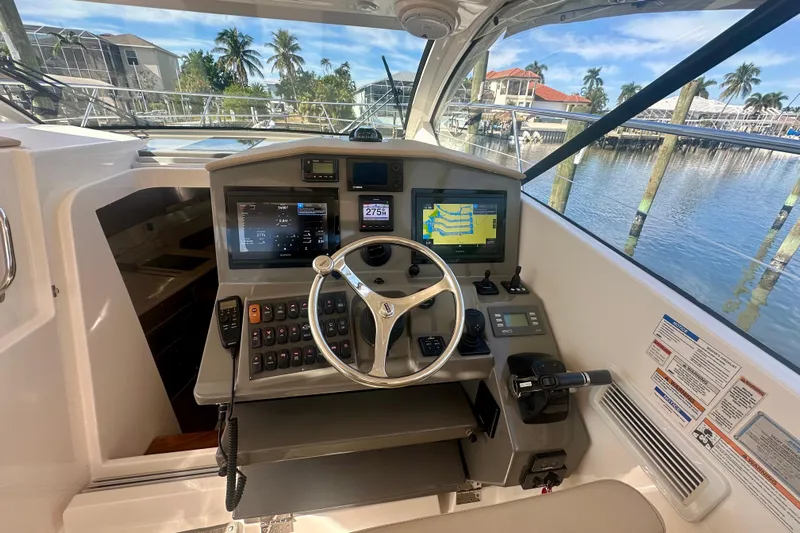  Yacht Photos Pics 2015 Pursuit SC 365i Sport Coupe helm with navigation screens and steering wheel.