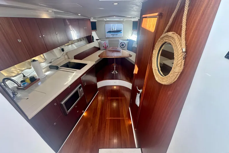  Yacht Photos Pics Luxurious interior of 2015 Pursuit SC 365i Sport Coupe with modern kitchen and seating area.