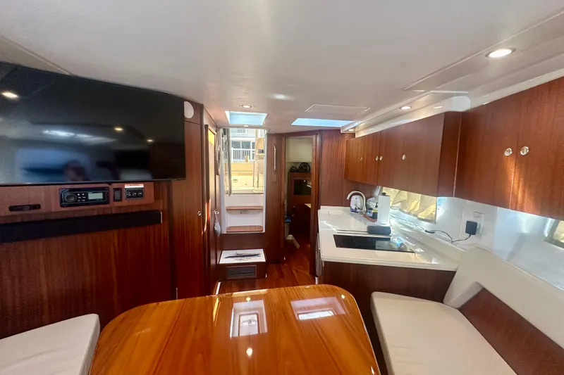  Yacht Photos Pics Luxurious interior of 2015 Pursuit SC 365i Sport Coupe with wood finishes and modern amenities.