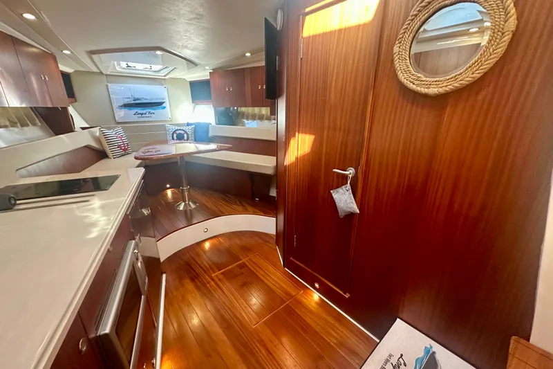  Yacht Photos Pics 2015 Pursuit SC 365i Sport Coupe interior with wood finish and cozy seating area.