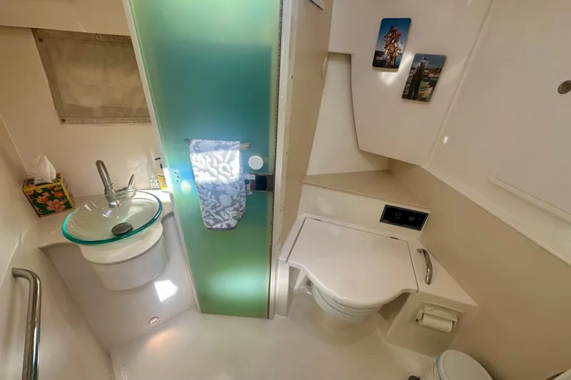  Yacht Photos Pics 2015 Pursuit SC 365i Sport Coupe bathroom with modern sink, toilet, and decor.