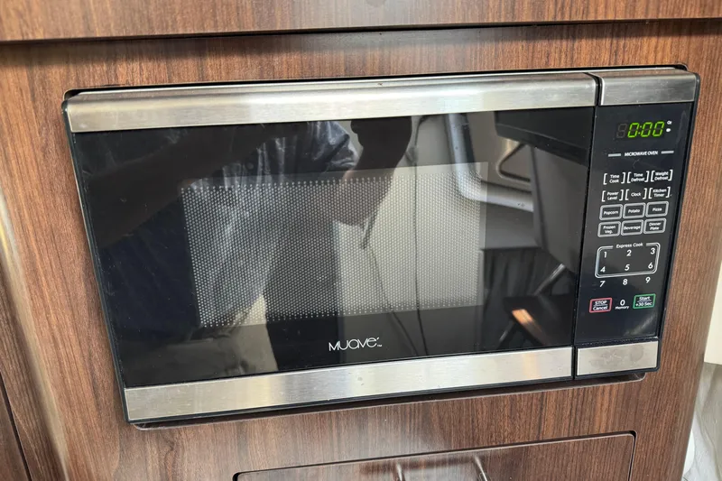 Don't Ask Yacht Photos Pics Microwave oven in 2018 Regal 28 Express boat interior, wood paneling background.