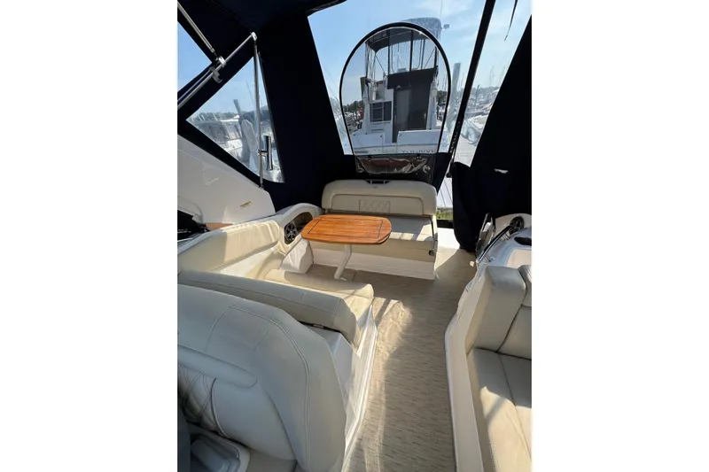 Don't Ask Yacht Photos Pics 2018 Regal 28 Express boat interior with seating and wooden table, featuring a covered cockpit.