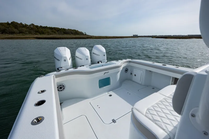  Yacht Photos Pics 2024 Yellowfin 34 Offshore boat with triple outboard engines on calm water.