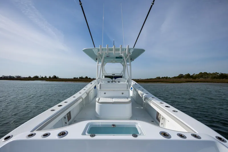  Yacht Photos Pics 2024 Yellowfin 34 Offshore boat on calm water, showcasing spacious deck and sleek design.
