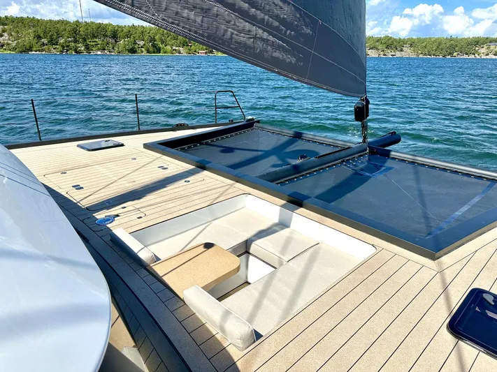  Yacht Photos Pics Luxurious 2025 Vaan R5 yacht deck with seating, sailing on a serene lake.
