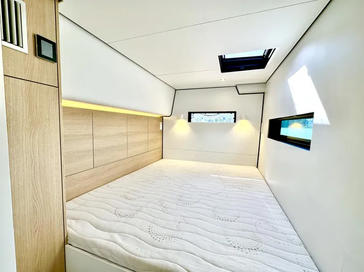 Yacht Photos Pics Modern Vaan R5 2025 interior with cozy bed, skylight, and wooden accents.