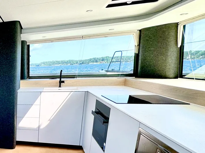  Yacht Photos Pics Modern kitchen interior on Vaan R5 yacht, 2025 model, with ocean view through large windows.