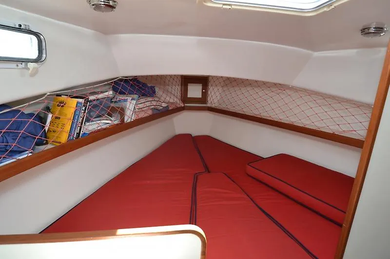 Grey Goose Yacht Photos Pics Interior cabin of 2002 West Bay 31 boat with red cushions and storage netting.