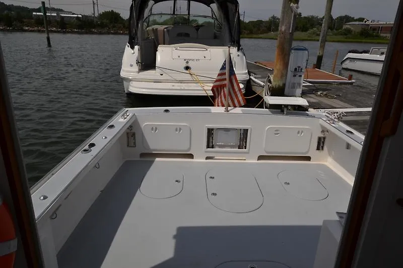 Grey Goose Yacht Photos Pics 2002 West Bay 31 boat docked, featuring spacious deck and American flag.