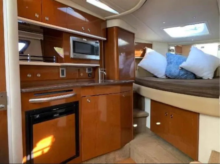  Yacht Photos Pics Interior of 2013 Sea Ray 330 Sundancer yacht with kitchenette and cozy sleeping area.