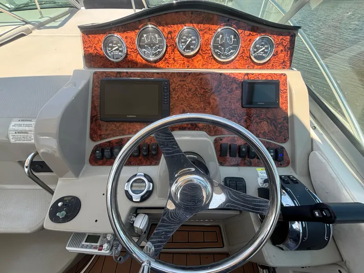  Yacht Photos Pics 2013 Sea Ray 330 Sundancer helm with wood paneling and modern gauges.