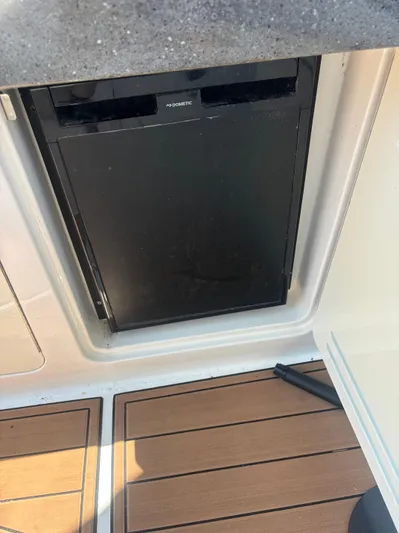  Yacht Photos Pics 2013 Sea Ray 330 Sundancer boat interior with built-in refrigerator and wooden flooring.