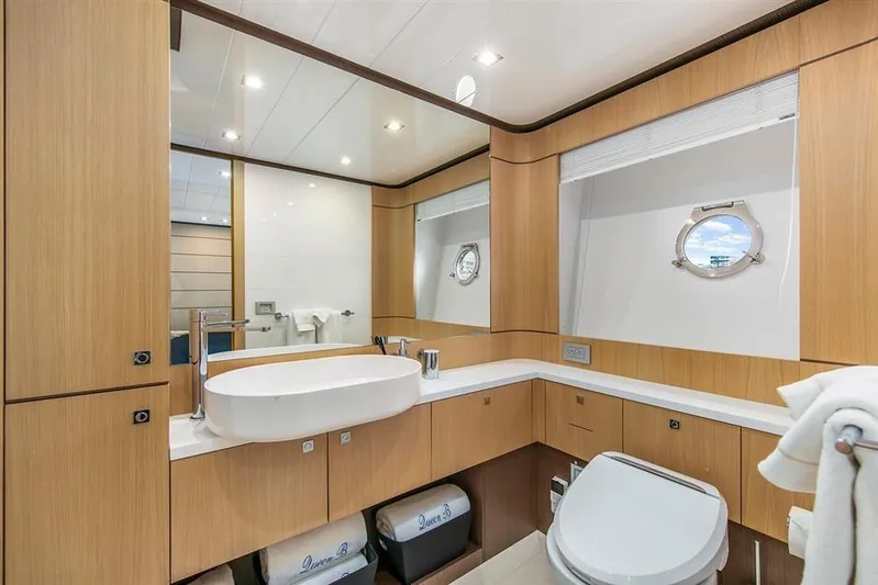 Lontano Yacht Photos Pics Luxurious bathroom on 2016 Ferretti 960 yacht with modern fixtures and wooden cabinetry.