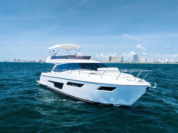 Ferretti 500 Yacht Photos Pics 2024 Ferretti Yachts 500 cruising on blue ocean near city skyline.