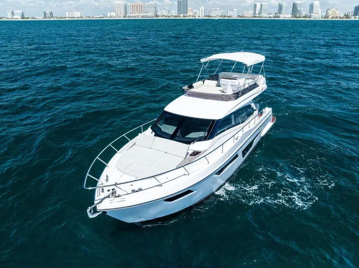 Ferretti 500 Yacht Photos Pics 2024 Ferretti Yachts 500 cruising on open water with city skyline in background.