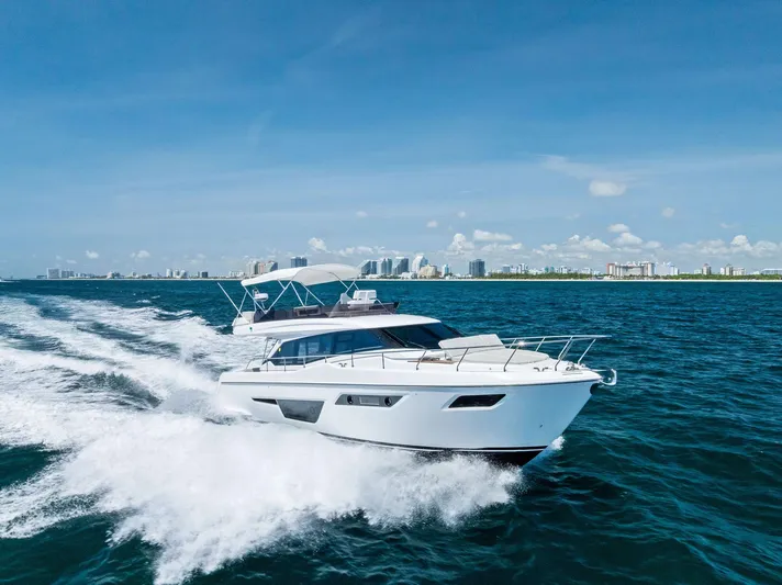 Ferretti 500 Yacht Photos Pics 2024 Ferretti Yachts 500 cruising on open water with city skyline in background.
