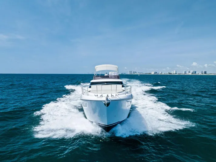 Ferretti 500 Yacht Photos Pics 2024 Ferretti Yachts 500 cruising on open sea with city skyline in background.