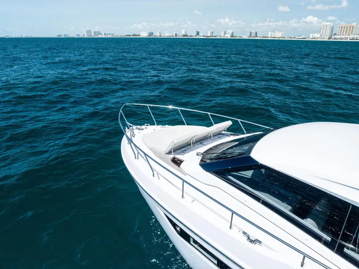 Ferretti 500 Yacht Photos Pics 2024 Ferretti Yachts 500 cruising on blue ocean near city skyline.