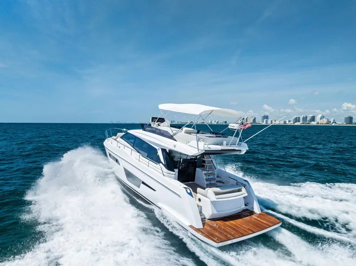 Ferretti 500 Yacht Photos Pics 2024 Ferretti Yachts 500 cruising on open sea with city skyline in background.